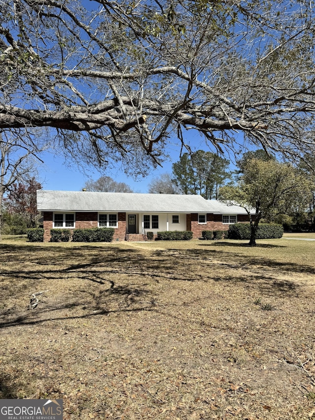 single story home featuring a front lawn and brick siding