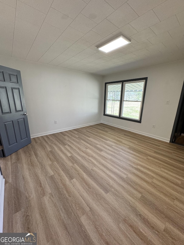 empty room with baseboards and wood finished floors