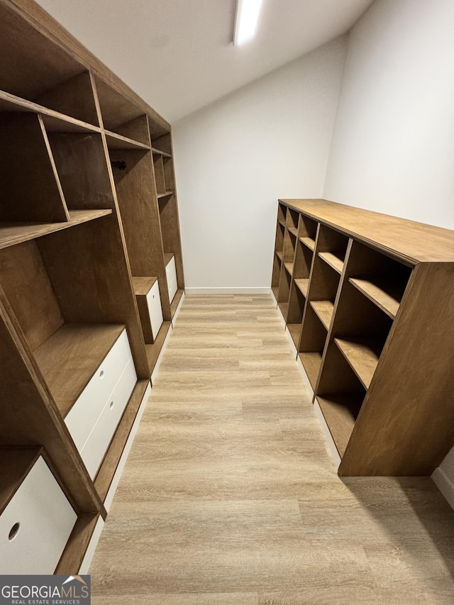 walk in closet with light wood-style flooring