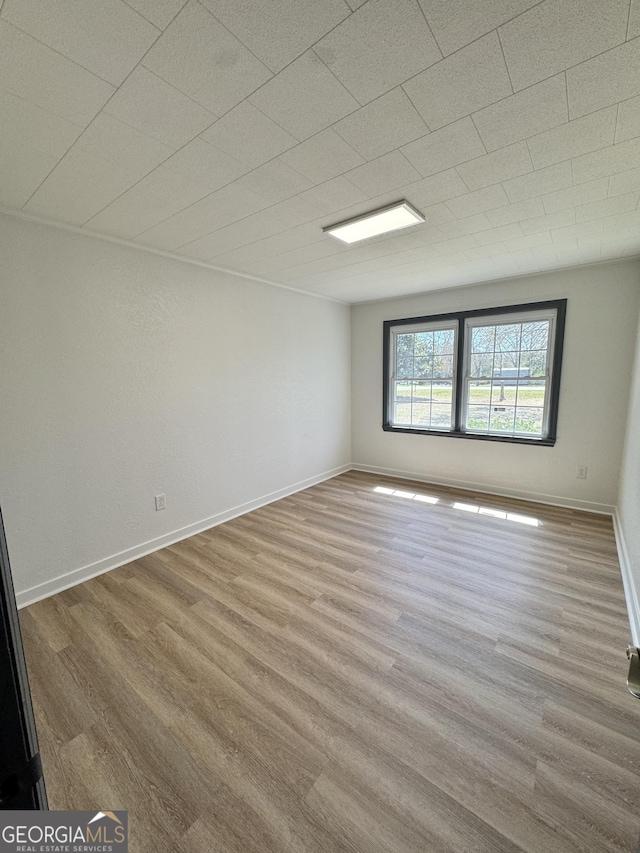 spare room with wood finished floors and baseboards