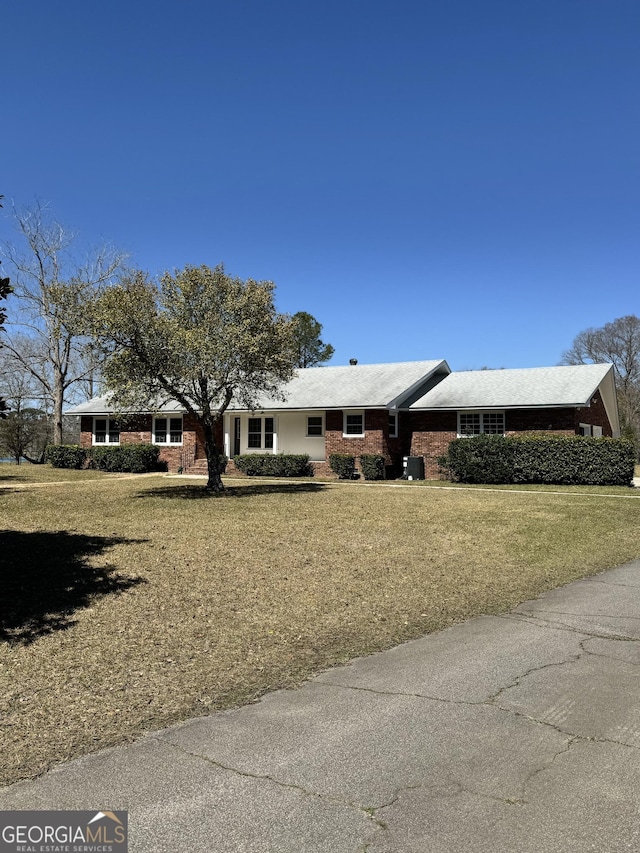 ranch-style home with brick siding and a front yard