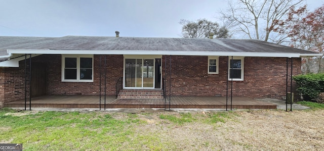 view of side of home with brick siding and a deck