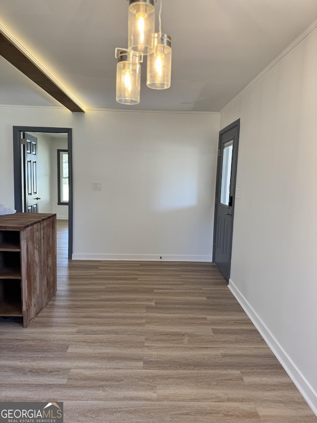 unfurnished dining area with crown molding, baseboards, and light wood finished floors