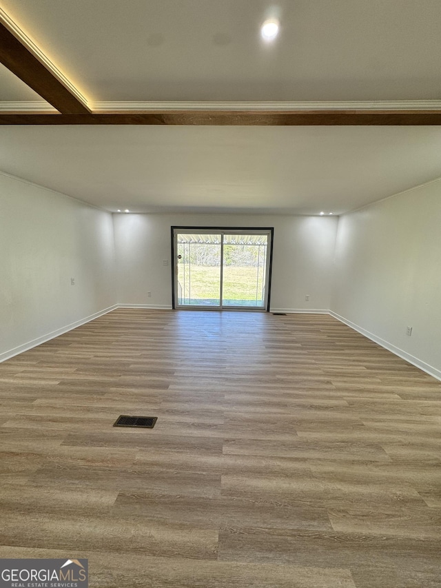 unfurnished room with visible vents, baseboards, and wood finished floors