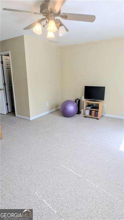 workout area featuring baseboards and a ceiling fan