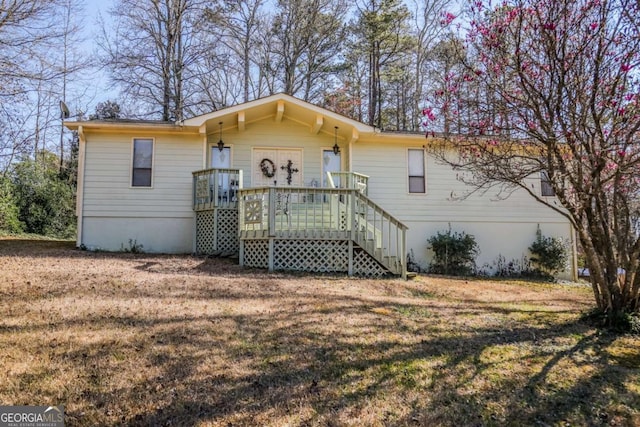 view of front facade with a deck and a front lawn