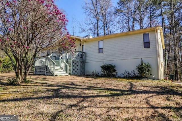 view of home's exterior with stairs and a yard