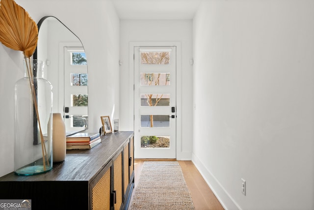 hallway with light wood finished floors and baseboards