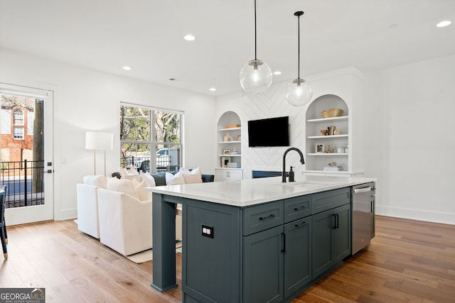 kitchen with light wood-type flooring, built in shelves, a sink, open floor plan, and dishwasher