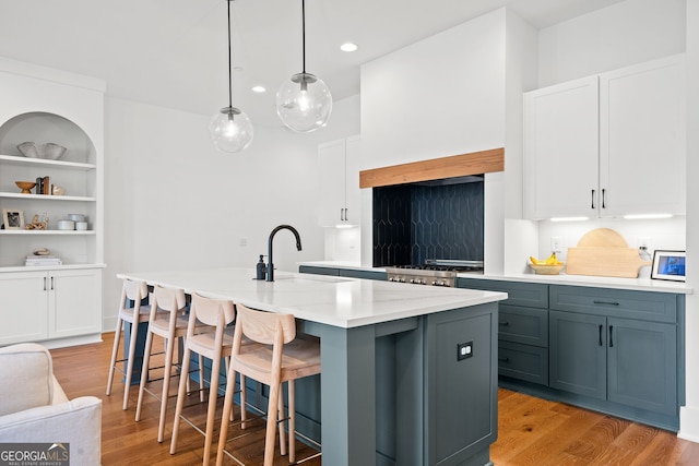 kitchen featuring light countertops, white cabinets, and a sink