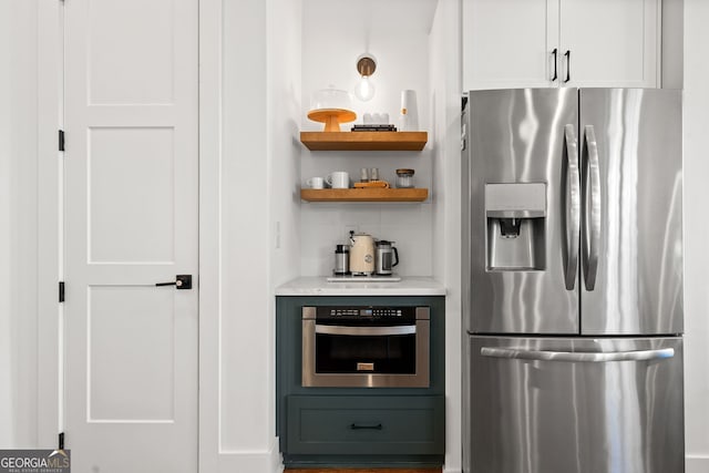 kitchen with decorative backsplash, open shelves, white cabinets, and appliances with stainless steel finishes