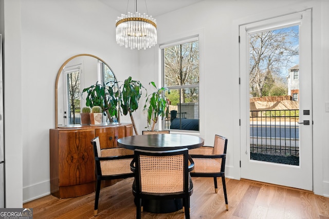 dining room with baseboards, an inviting chandelier, and wood finished floors