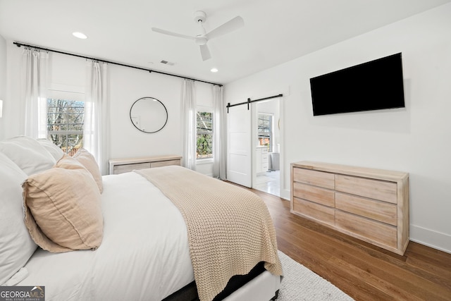 bedroom with ceiling fan, baseboards, a barn door, recessed lighting, and dark wood-style flooring