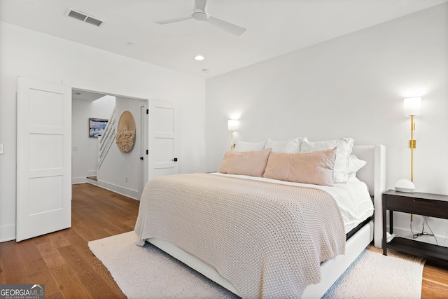 bedroom with a ceiling fan, wood finished floors, visible vents, baseboards, and recessed lighting