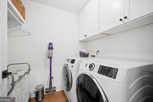 clothes washing area with baseboards, cabinet space, separate washer and dryer, and wood finished floors