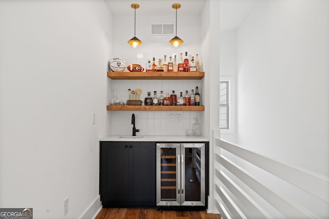 2712 Stargazer Ter, Smyrna, GA 30080 - indoor wet bar with beverage cooler, dark wood-type flooring, decorative backsplash, and decorative light fixtures