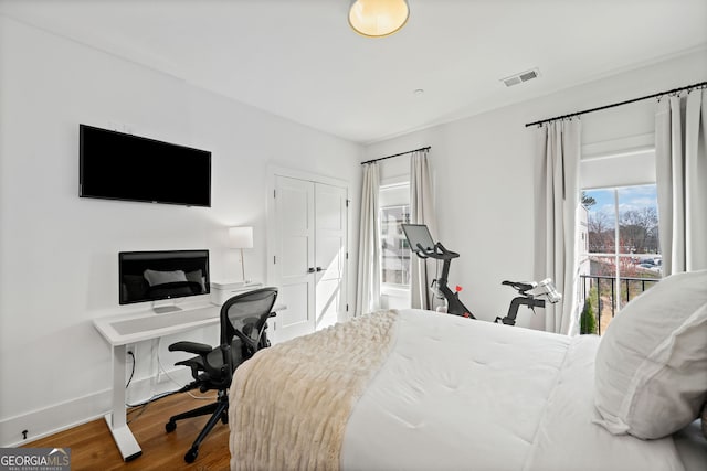 bedroom featuring visible vents, baseboards, and wood finished floors