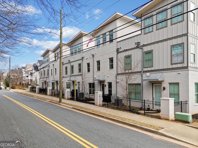 view of building exterior featuring fence and a residential view