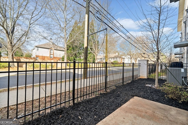 view of yard with a residential view, central AC, and fence