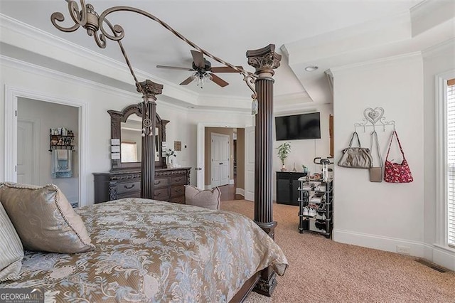 carpeted bedroom featuring visible vents, ornamental molding, a tray ceiling, decorative columns, and baseboards