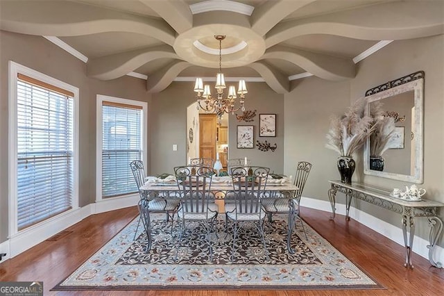 dining area featuring crown molding, wood finished floors, baseboards, and a chandelier