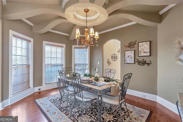 dining space featuring a notable chandelier, plenty of natural light, crown molding, and wood finished floors