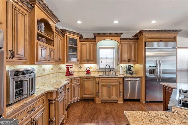 kitchen with light stone counters, dark wood-style floors, a toaster, a sink, and appliances with stainless steel finishes