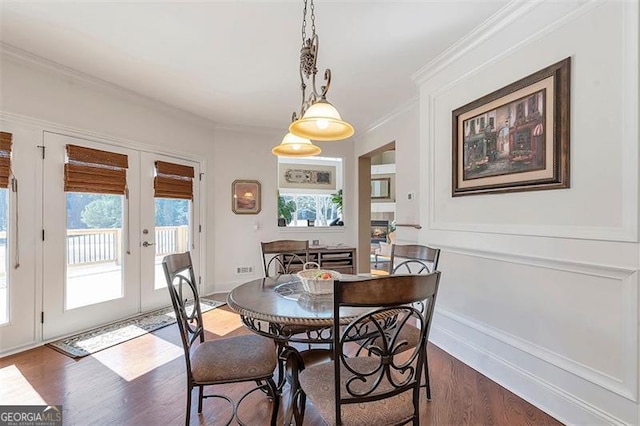 dining space featuring french doors, dark wood finished floors, and crown molding