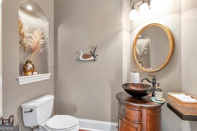 bathroom featuring vanity, toilet, and baseboards