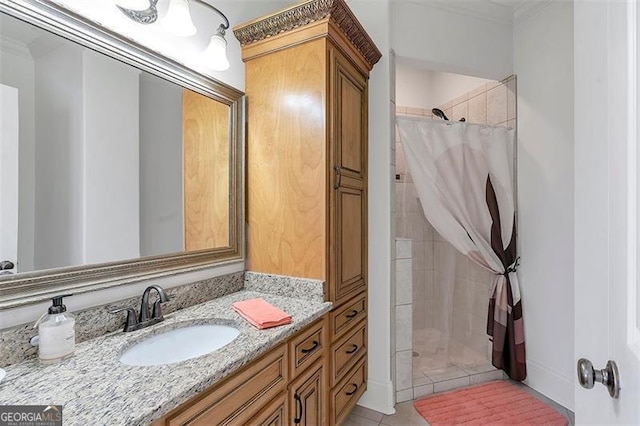 bathroom featuring tile patterned floors, crown molding, vanity, and a tile shower