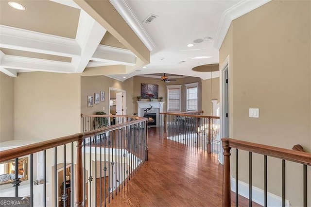 hallway with wood finished floors, visible vents, coffered ceiling, beam ceiling, and crown molding