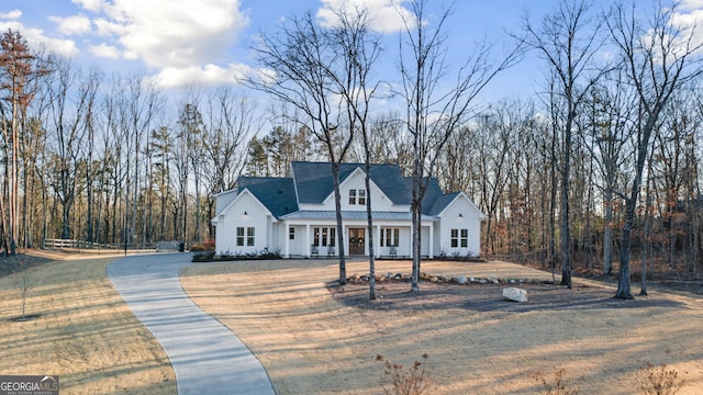 modern farmhouse style home featuring board and batten siding, metal roof, and a front yard