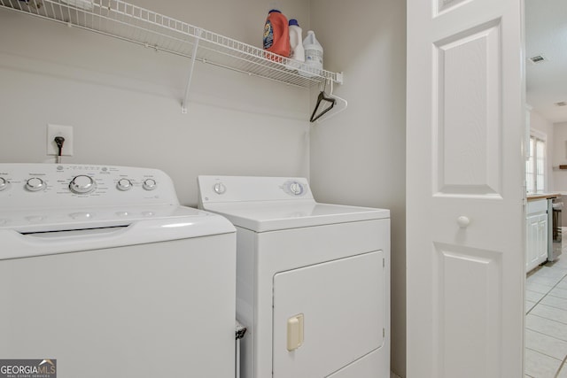 laundry area with laundry area, light tile patterned floors, visible vents, and washing machine and clothes dryer