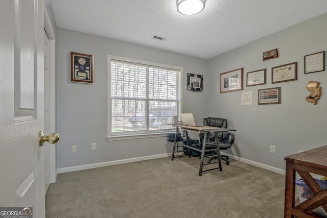 carpeted home office with visible vents, baseboards, and a textured ceiling