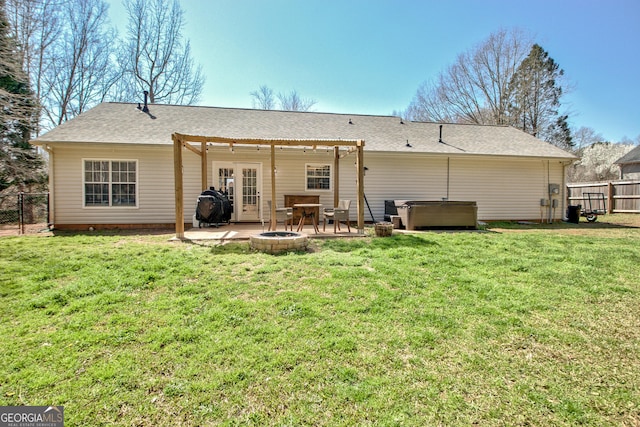 rear view of house with a patio, a yard, fence, and a hot tub