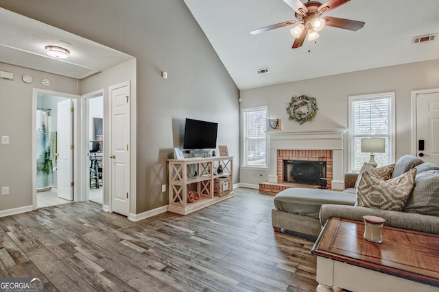 living room featuring visible vents, plenty of natural light, and wood finished floors