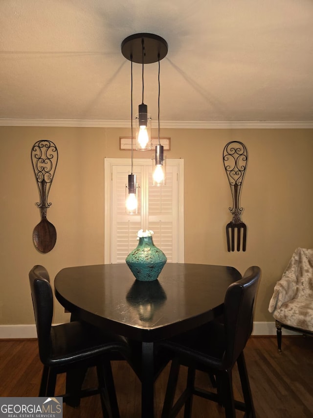 dining area featuring crown molding, dark wood-type flooring, and baseboards