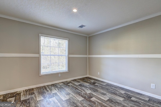 spare room with visible vents, baseboards, a textured ceiling, and wood finished floors