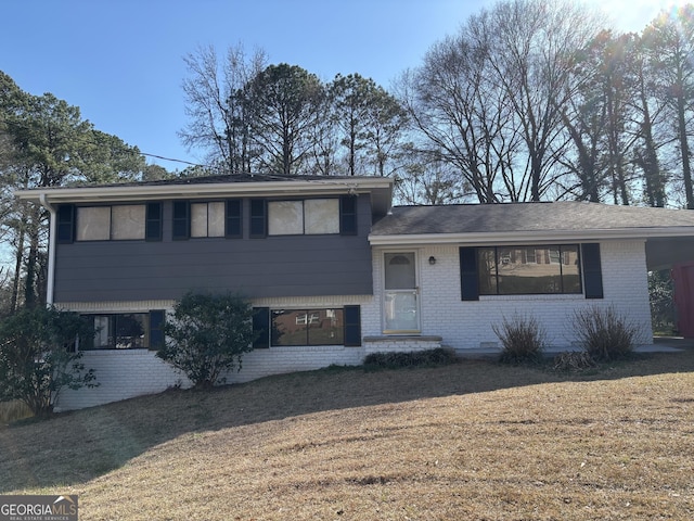 tri-level home with a front yard and brick siding