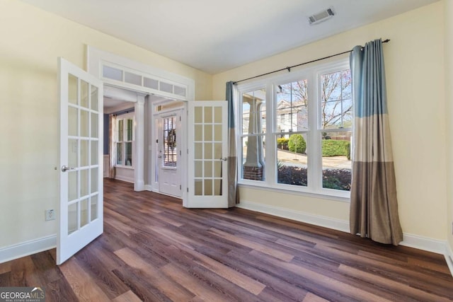 interior space with visible vents, french doors, dark wood-type flooring, and baseboards