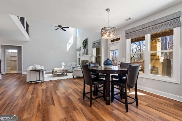 dining room with ceiling fan, visible vents, baseboards, and wood finished floors