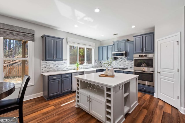 kitchen with a center island, dark wood finished floors, light countertops, appliances with stainless steel finishes, and open shelves