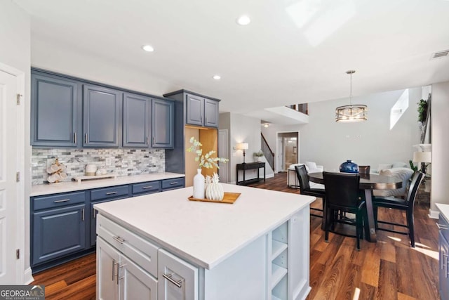 kitchen featuring tasteful backsplash, dark wood-type flooring, open floor plan, and light countertops