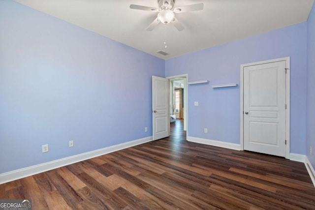 unfurnished bedroom featuring dark wood-style floors, visible vents, ceiling fan, and baseboards