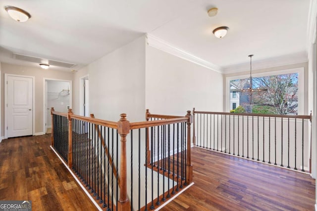 hall featuring crown molding, baseboards, an upstairs landing, wood finished floors, and a notable chandelier