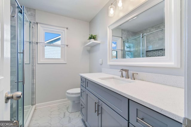 bathroom featuring tile patterned floors, toilet, tiled shower, baseboards, and vanity