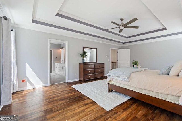 bedroom featuring crown molding, baseboards, dark wood-type flooring, and a tray ceiling