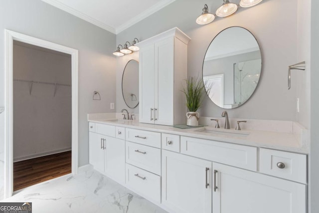 full bath with a sink, a spacious closet, marble finish floor, and crown molding