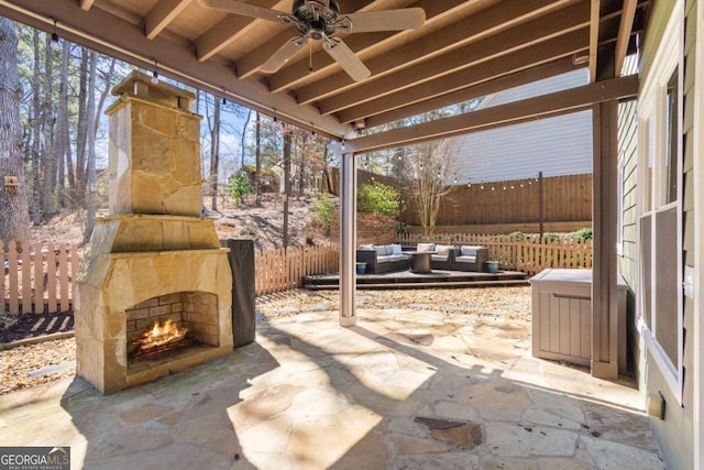 view of patio / terrace featuring an outdoor living space with a fireplace, fence, and ceiling fan