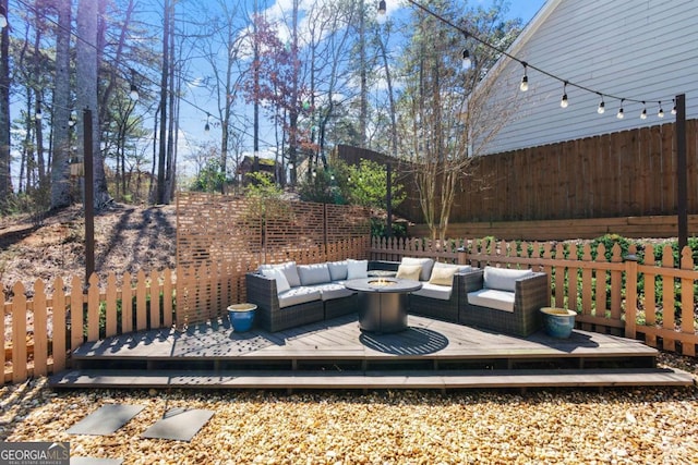 view of patio featuring a fenced backyard, an outdoor living space with a fire pit, and a deck